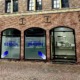 Straßenansicht der modernen Büroräume von Berson in Kranenburg, mit drei großen Fenstern in einer roten Backsteinfassade. Auf den Fenstern steht der Firmenname ‚BERSON‘ in blauer Schrift.