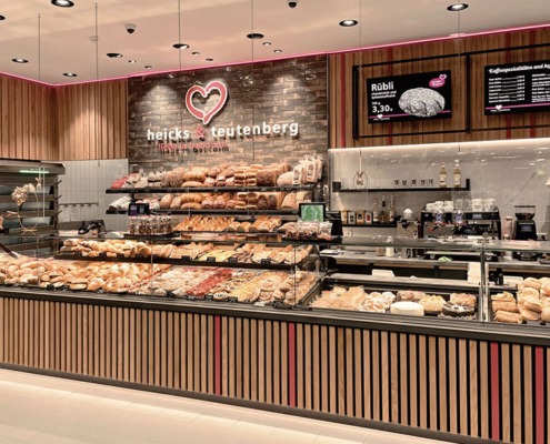 Moderne Theke der Bäckerei und Konditorei heicks & teutenberg liebe in backform mit großer Auslage an Backwaren und diversen Kuchen und Snacks