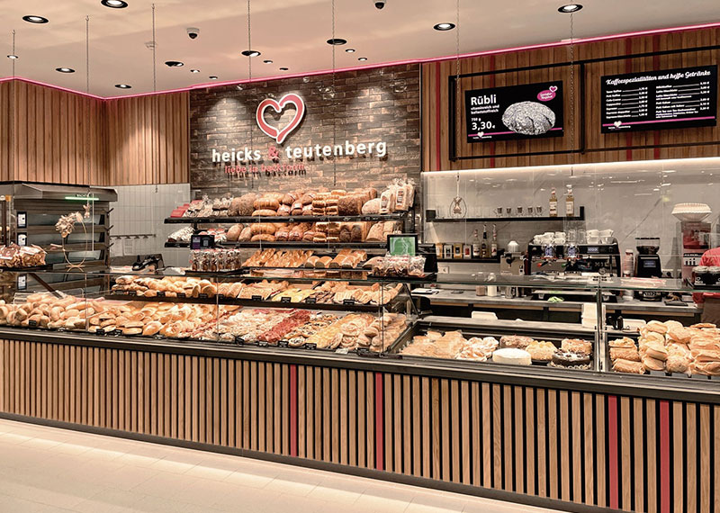 Moderne Theke der Bäckerei und Konditorei heicks & teutenberg liebe in backform mit großer Auslage an Backwaren und diversen Kuchen und Snacks