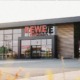 Moderne Außenansicht des REWE-Markts Averbeck in Kranenburg mit großen Glasfassaden, begrüntem Wandbereich und separatem Leergut-Eingang.