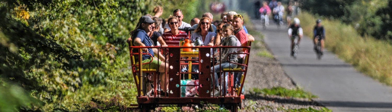 Fröhliche Menschen bei schönem Wetter auf einer Club-Draisine der Grenzland-Draisine GmbH (Foto: Markus van Offern/Gemeinde Kranenburg)